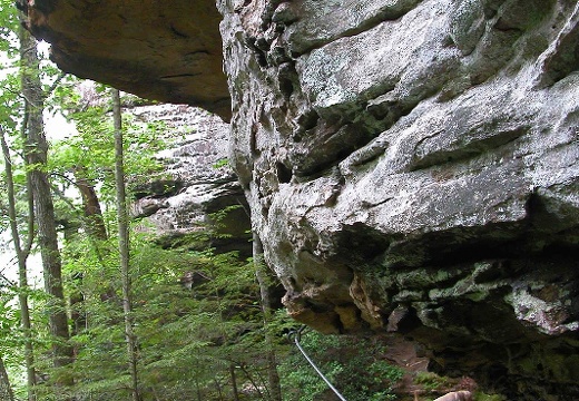 Cable on trail around rock outcrop. 